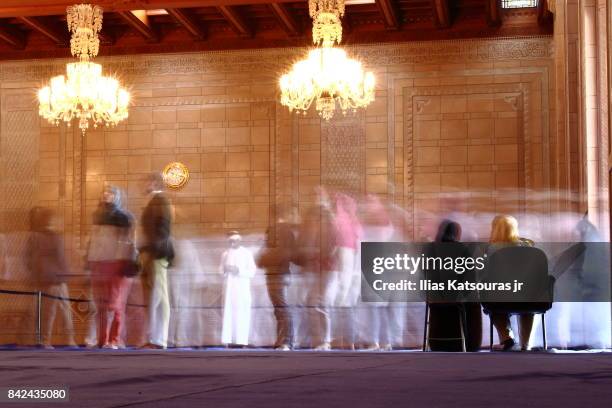 long exposure of visitors moving in and out of the ladies prayer hall in the sultan qaboos grand mosque in muscat, oman - arabian peninsula fotografías e imágenes de stock