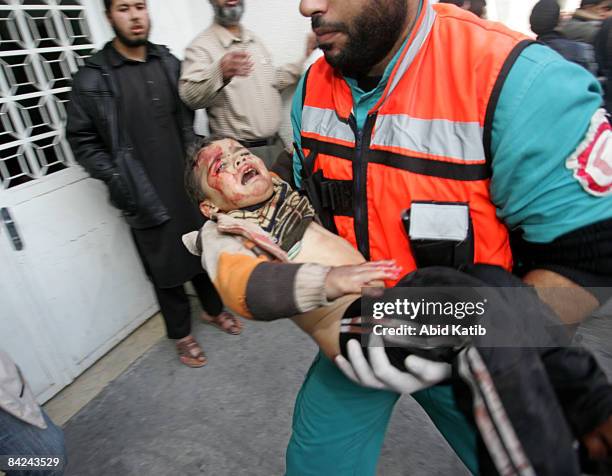 Wounded Palestinian child is carried into the Kamal Adwan hospital after an Israeli air strike on January 11, 2009 in Beit Lahia, northern Gaza...