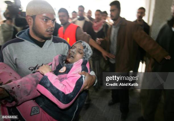 Wounded Palestinian girl is carried into the Al-Shifa hospital after an Israeli air strike on January 11, 2009 in Gaza City, Gaza Strip. According to...