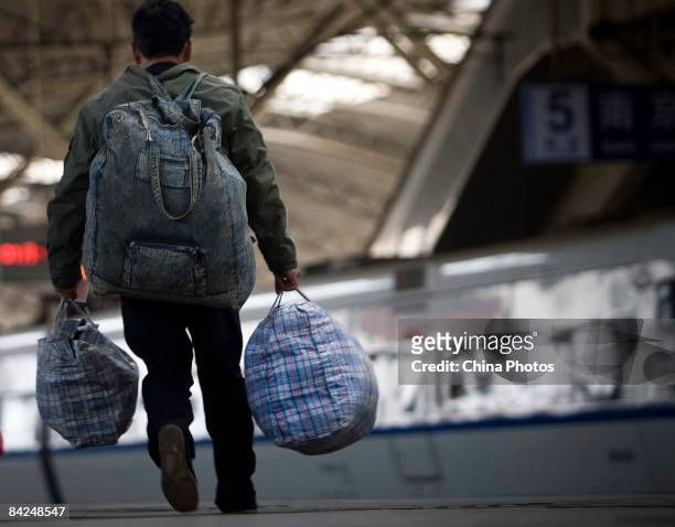 Passenger goes to board a train at the Hefei Railway Station on January 11, 2009 in Hefei of Anhui Province, China. Spring Festival travel season has...