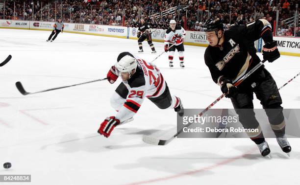 Johnny Oduya of the New Jersey Devils trips chasing the puck against Ryan Getzlaf of the Anaheim Ducks during the game on January 11, 2009 at Honda...
