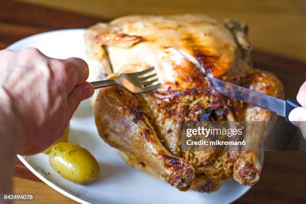 cropped hand cutting roasted chicken. homemade roasted chicken whit spices for dinner - folha de alumínio - fotografias e filmes do acervo