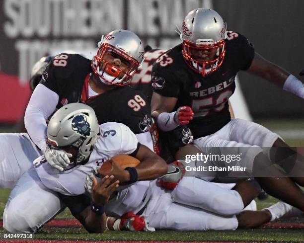 Quarterback Caylin Newton of the Howard Bison is tackled after running for a six-yard gain by defensive lineman Mike Hughes Jr. #99 and linebacker...