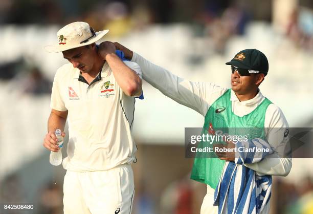 Pat Cummins of Australia is given a cold towel by Usman Khawaja of Australia during day one of the Second Test match between Bangladesh and Australia...
