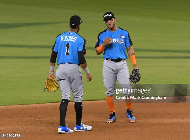 New York Mets prospect Amed Rosario and Chicago White Sox prospect Yoan Moncada of the World Team stand together on the field during the 2017...