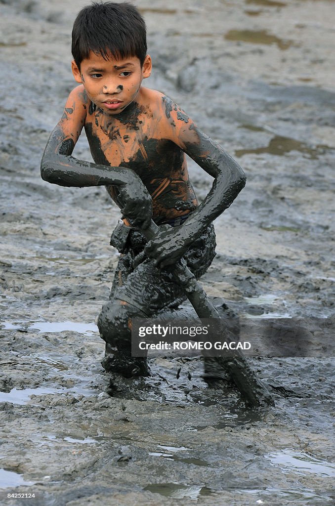 Filipino children catch crabs in a pond