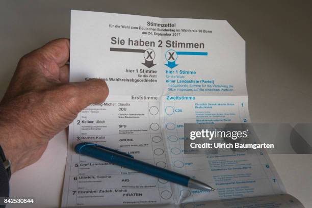 Federal elections 2017. The photo shows a hand with a vote label and a ballpoint pen.