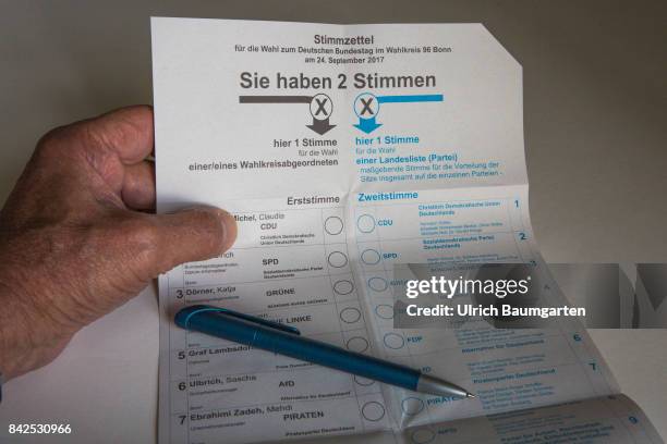 Federal elections 2017. The photo shows a hand with a vote label and a ballpoint pen.