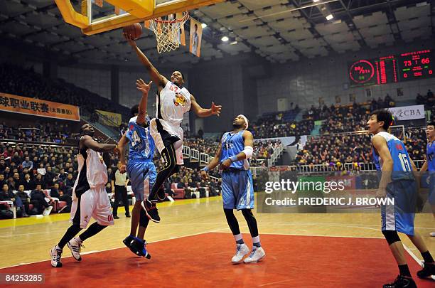 Basket-CHN-NBA-CBA-Wells" by Robert Saiget Former NBA star Bonzi Wells rises to score between fellow-US opponents David Harrison and Dontae Jones as...