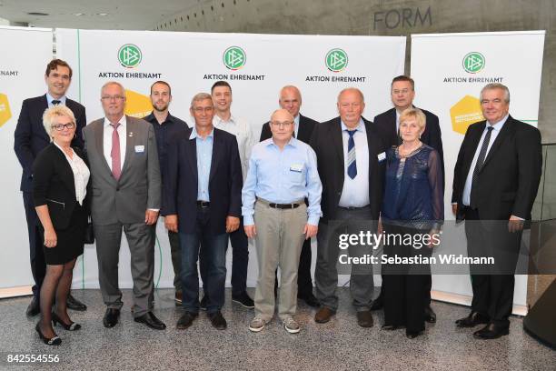 President Reinhard Grindel, DFB general secretary Dr. Friedrich Curtius and DFB vice president Peter Frymuth pose with members of the Football...