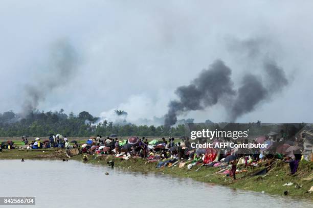 Smoke billows above what is believed to be a burning village in Myanmar's Rakhine state as members of the Rohingya Muslim minority take shelter in a...