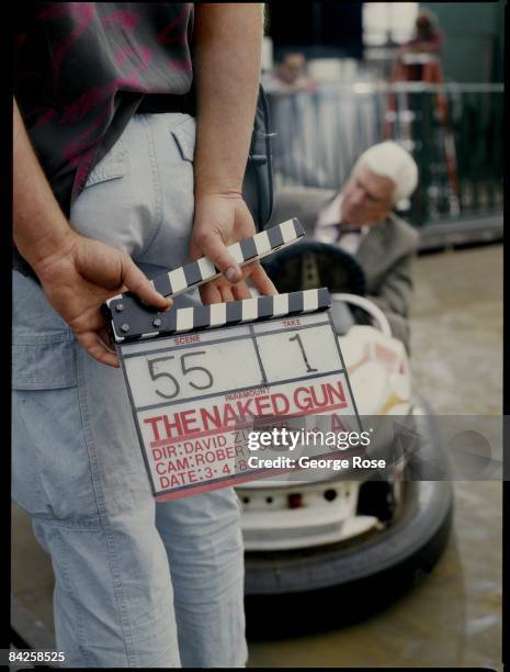 Actor Leslie Nielsen sits in an electric bumper car during the 1988 Santa Monica, California, filming of the hit movie "The Naked Gun."