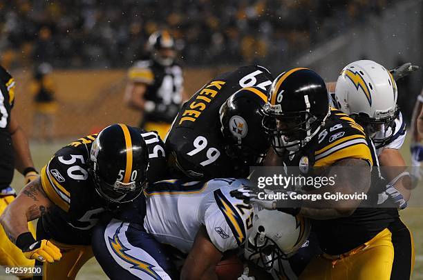 Linebackers Larry Foote and LaMarr Woodley and defensive lineman Brett Keisel of the Pittsburgh Steelers tackle running back Michael Bennett of the...