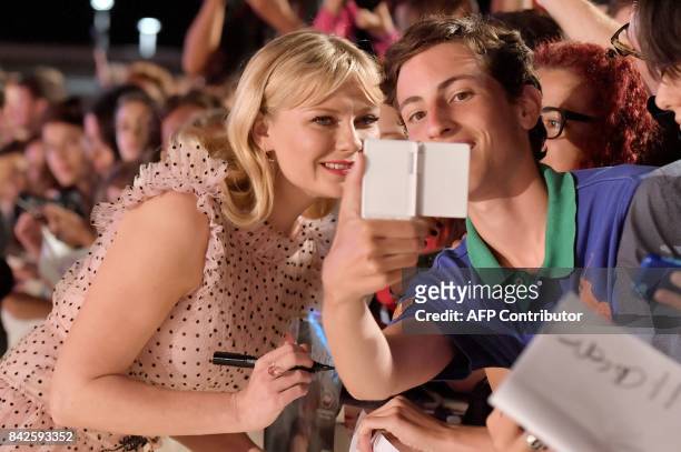 Actress Kirsten Dunst poses with fans and signs autographs the premiere of the movie "Woodshock" presented in the "Cinema nel Giardino" selection at...