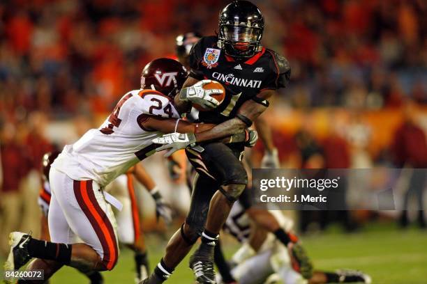 Receiver Mardy Gilyard of the Cincinnati Bearcats looks to break the tackle of defender Dorian Porch of the Virginia Tech Hokies during the FedEx...