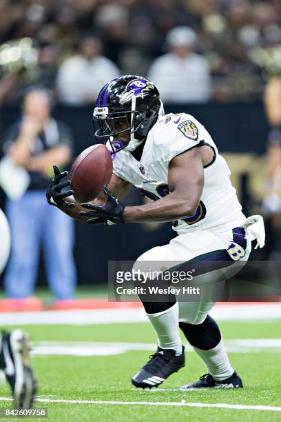 Bobby Rainey of the Baltimore Ravens mishandles the handoff during a preseason game against the New Orleans Saints at Mercedes-Benz Superdome on...