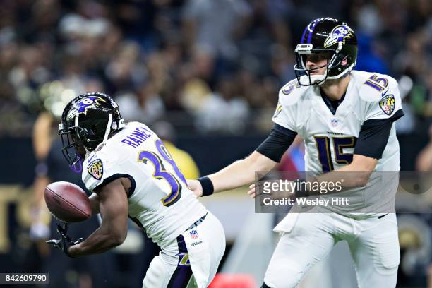 Ryan Mallett hands off the ball to Bobby Rainey of the Baltimore Ravens during a preseason game against the New Orleans Saints at Mercedes-Benz...