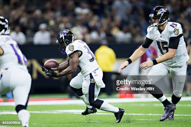 Ryan Mallett hands off the ball to Bobby Rainey of the Baltimore Ravens during a preseason game against the New Orleans Saints at Mercedes-Benz...