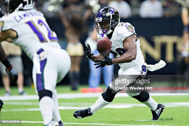 Bobby Rainey of the Baltimore Ravens mishandles the handoff during a preseason game against the New Orleans Saints at Mercedes-Benz Superdome on...