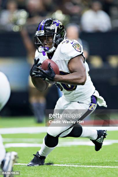 Bobby Rainey of the Baltimore Ravens mishandles the handoff during a preseason game against the New Orleans Saints at Mercedes-Benz Superdome on...