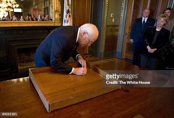 In this handout image provided by the White House, U.S. Vice President Dick Cheney signs the inside of the top drawer of his desk in the Vice...