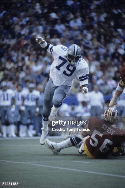 Defensive lineman Harvey Martin of the Dallas Cowboys leaps over the legs of the lineman on the ground during a game on December 13, 1975 against the...