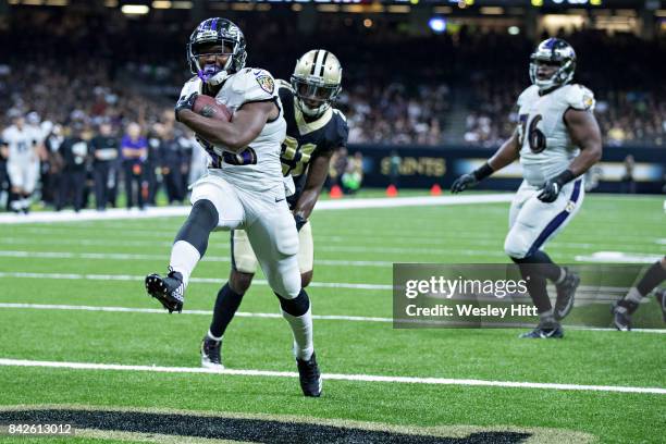 Bobby Rainey of the Baltimore Ravens rushes for a touchdown past De'Vante Harris of the New Orleans Saints during a preseason game at Mercedes-Benz...