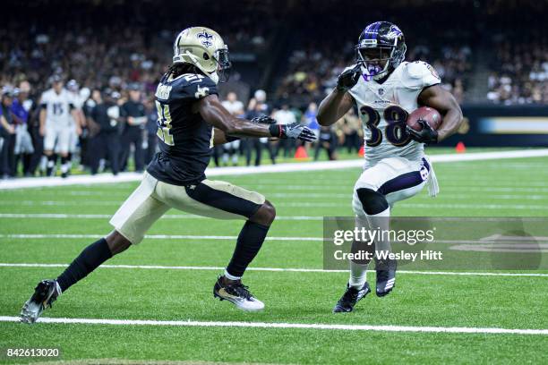 Bobby Rainey of the Baltimore Ravens rushes for a touchdown past De'Vante Harris of the New Orleans Saints during a preseason game at Mercedes-Benz...