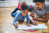 Father and daughter coloring together