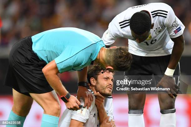 Jonas Hector of Germany is being checked on by referee Gediminas Mazeika and Antonio Ruediger of Germany during the FIFA 2018 World Cup Qualifier...