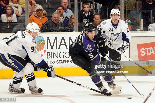 Peter Harrold of the Los Angeles Kings controls the puck against Steven Stamkos and Matt Pettinger of the Tampa Bay Lightning against during the game...