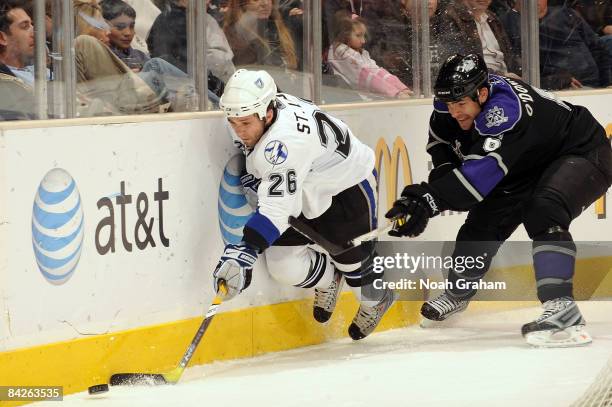 Martin St. Louis of the Tampa Bay Lightning chases the puck alongside the boards against Sean O'Donnell of the Los Angeles Kings during the game on...