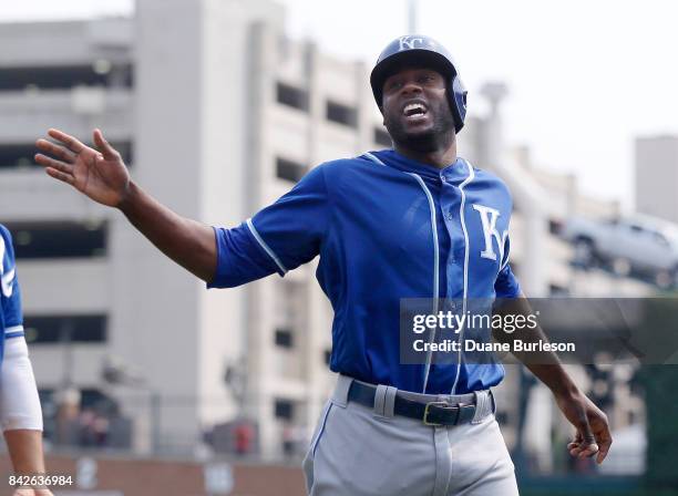 Lorenzo Cain of the Kansas City Royals celebrates after scoring against the Detroit Tigers on a double by Melky Cabrera during the third inning at...