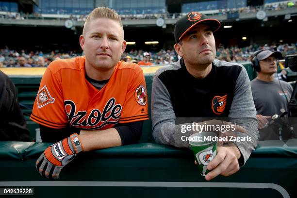 Mark Trumbo and Seth Smith of the Baltimore Orioless stand in the dugout prior to the game against the Oakland Athletics at the Oakland Alameda...