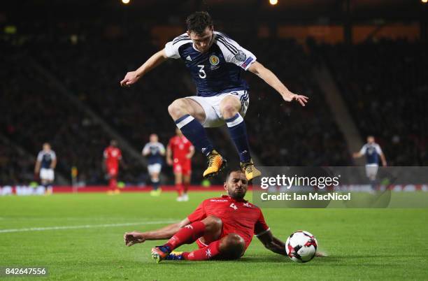 Andy Robertson of Scotland leaps over Steve Borg of Malta during the FIFA 2018 World Cup Qualifier between Scotland and Malta at Hampden Park on...