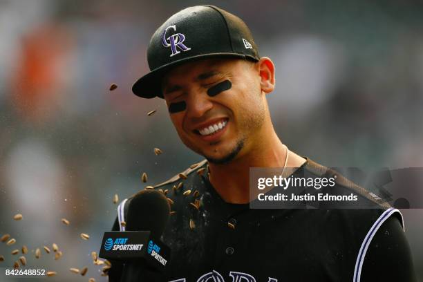 Carlos Gonzalez of the Colorado Rockies is doused with sunflower seeds during a TV interview following his walk-off walk in the ninth inning that...