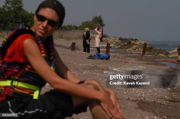 Young woman on the beach after a jet-ski ride at Bandar-e Anzali on the Caspian Sea coast of Iran, 22nd July 2005. Wearing short sleeves and...