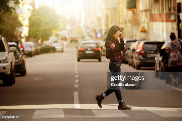 woman using phone, stockholm city street in background - stockholm park stock pictures, royalty-free photos & images