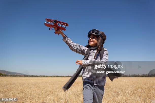 boy playing with toy airplane - aviation hat stock pictures, royalty-free photos & images