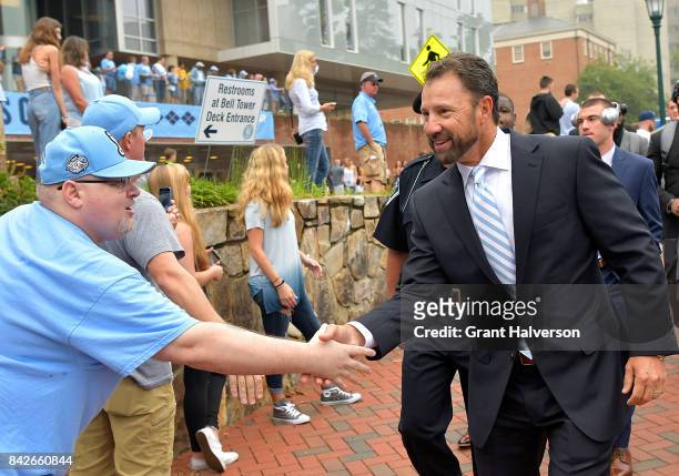 Fans greet head coach Larry Fedora of the North Carolina Tar Heels during their game against the California Golden Bears at Kenan Stadium on...