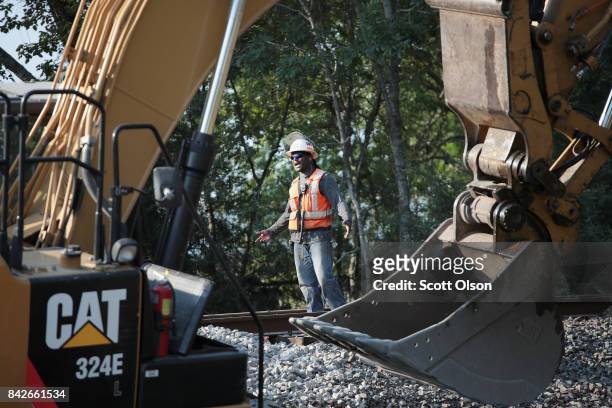 Workers repair a section of Union Pacific railroad tracks that were washed away by flooding during Hurricane and Tropical Storm Harvey on September...