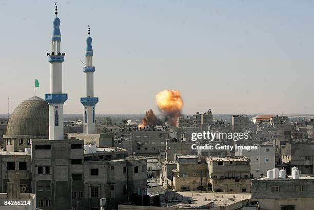 Flames and debris rise above the city following an Israeli air strike on January 13, 2009 in Rafah, Gaza Strip. Israel is intensifying its wide-scale...