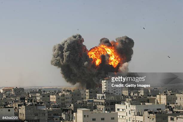 Flames and debris rise following an Israeli air strike on January 13, 2009 in Rafah, Gaza Strip. Israel is intensifying its wide-scale ground assault...