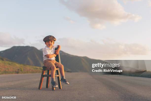 young boy salesman sits on stool with megaphone - child film director stock pictures, royalty-free photos & images