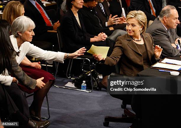 Secretary of State-designate and U.S. Senator Hillary Clinton passes a note to aids while testifying during her confirmation hearing before the...