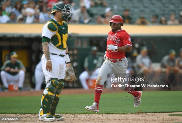 Eric Young Jr. #8 of the Los Angeles Angels of Anaheim scores against the Oakland Athletics in the top of the 11th inning at Oakland Alameda Coliseum...