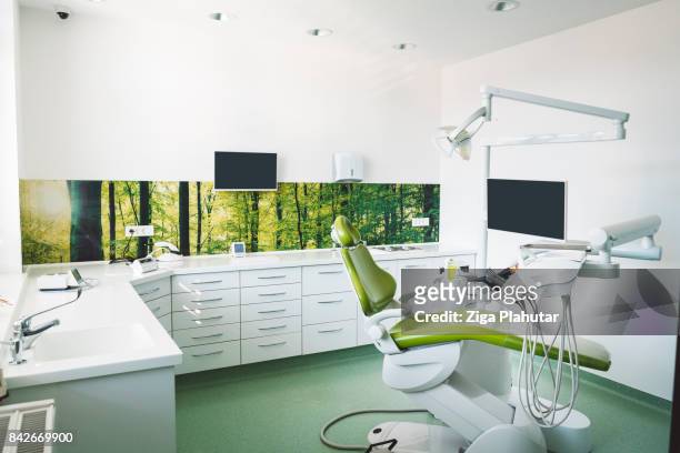 dentist's chair in brightly lit clinic - cadeira de dentista imagens e fotografias de stock