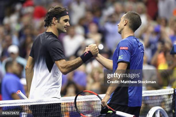 Roger Federer of Switzerland shakes hands with Philipp Kohlschreiber of Germany after defeating him in their men's singles fourth round match on Day...