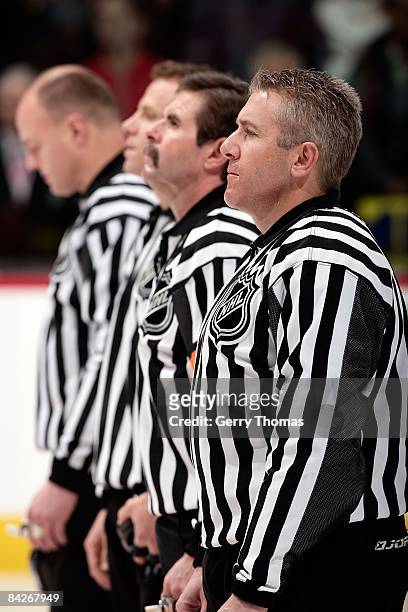 Referees Gord Dwyer and Bill McCreary and linesman Lonnie Cameron and Andy McElman stand for the National Anthems before the Calgary Flames game...