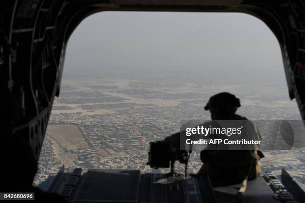 In this photograph taken on August 10 a US soldier sits in the rear of Chinook helicopter while flying over Kabul. Fresh recruits to Afghanistan's...